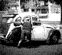 A man is dragging his old vintage car.