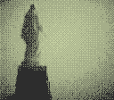 A statue of a woman from the back, on top of an hill.