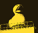 A giant inflatable rubber duck with its beak open wide, as if mid-quack. A railing runs across the lower part of the frame.